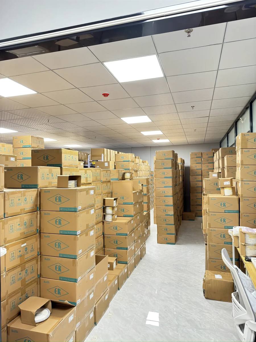 Huodian Electronics Shenzhen warehouse aisle — rows of ER-branded cardboard boxes with chip resistors, LEDs and IC reels in taped & reeled packaging, ready for worldwide export.