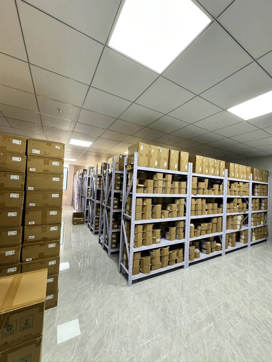 Huodian Electronics heavy-duty steel shelving system with labelled rack positions — thousands of small component boxes organized for fast FIFO order picking.